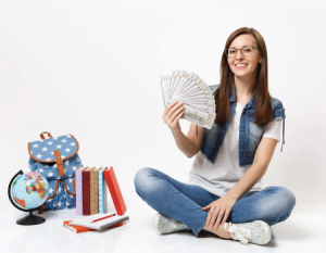 Jóven con dinero en la mano y útiles escolares al lado.