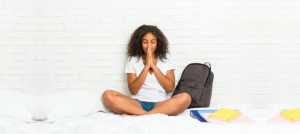 Mujer orando sobre su cama.