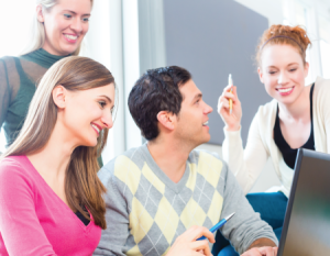 Grupo de jóvenes frente a un computador portátil.
