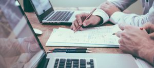 Personas realizando apuntes en una libreta.