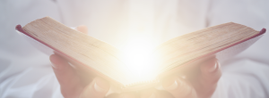 Biblia abierta y emitiendo una luz.