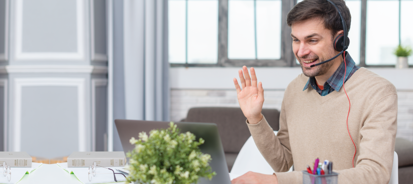 Tutor saludando con su mano a través de un computador.