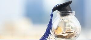 Frasco con monedas y un birrete.