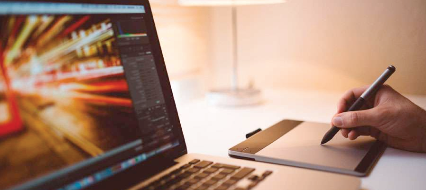 Computador portátil y mano sobre tableta digitalizadora.