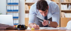 Investigador con una lupa en su mano revisa un documento.