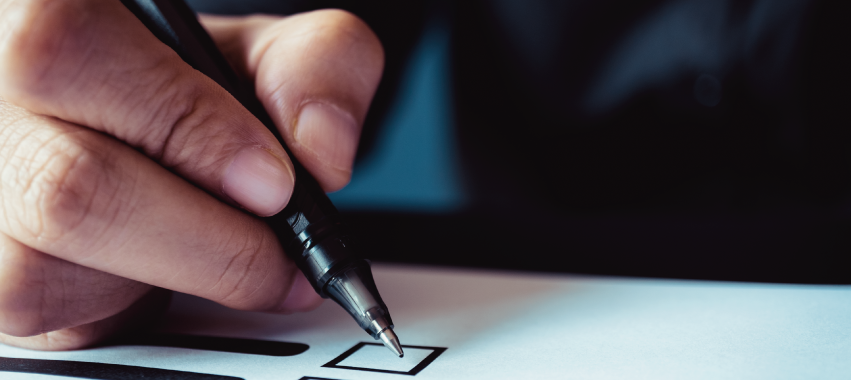 Mano con lapicero sobre una lista de chequeo.