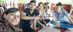 Cuatro jóvenes, sentados sobre el suelo, sonríen a la cámara.