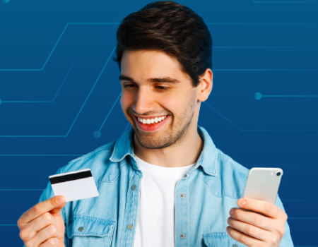 Joven con una tarjeta de crédito en su mano y un celular en la otra.
