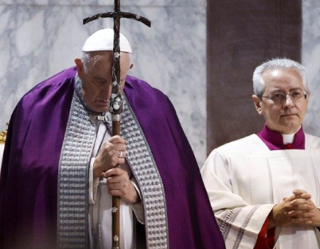 Papa Francisco sosteniendo una cruz.