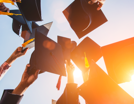 Manos de graduados sosteniendo virretes.