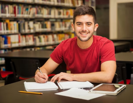Joven estudiando en una biblioteca.