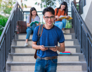 Tres jóvenes estudiantes universitarios en unas escalas utilizando material de estudio.