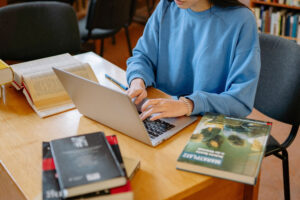 Mujer sentada escribiendo en un computador portatil