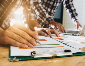 Personas realizando apuntos sobre unas hojas de papel.