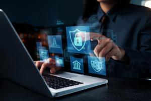 Íconos de seguridad superpuestos en un ambiente informático donde una persona interctúa con un computador portátil.