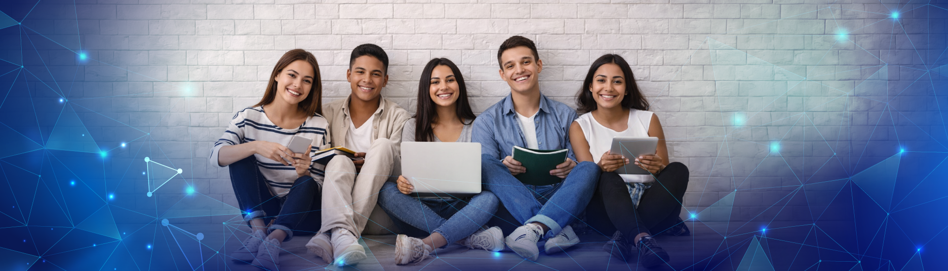 Grupo de jóvenes sentados, sonriendo, mientras sostienen libros, computador portátil y table