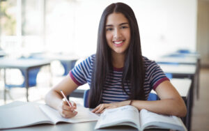 Mujer joven estudiante con libros y un lápiz.