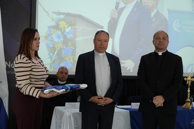 Entrega de la bandera institucional de la UCN durante la ceremonia de nombramiento del padre Eduin Alberto Salazar como rector.